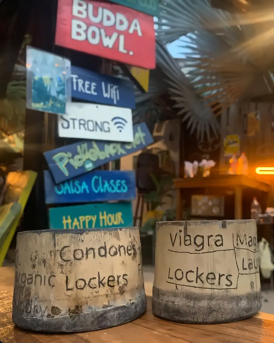 Letreros pintados a mano —«Budda Bowl», «Free WiFi», «Strong», «Salsa clases», «Happy hour»— y dos cubos de bambú marcados en broma «Organic lockers».